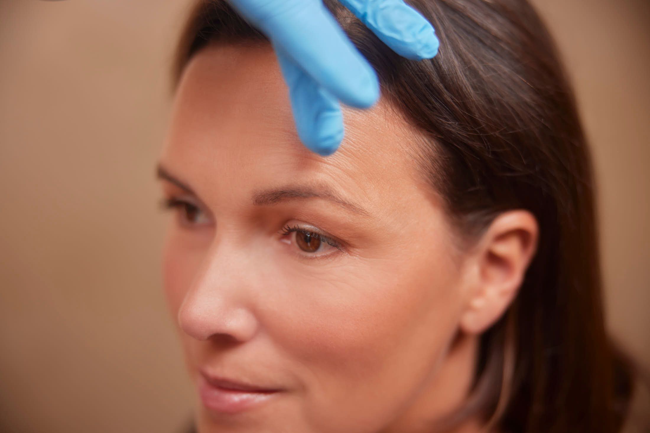 Cosmetisch arts voert bovenooglidcorrectie uit bij client bij The Body Clinic