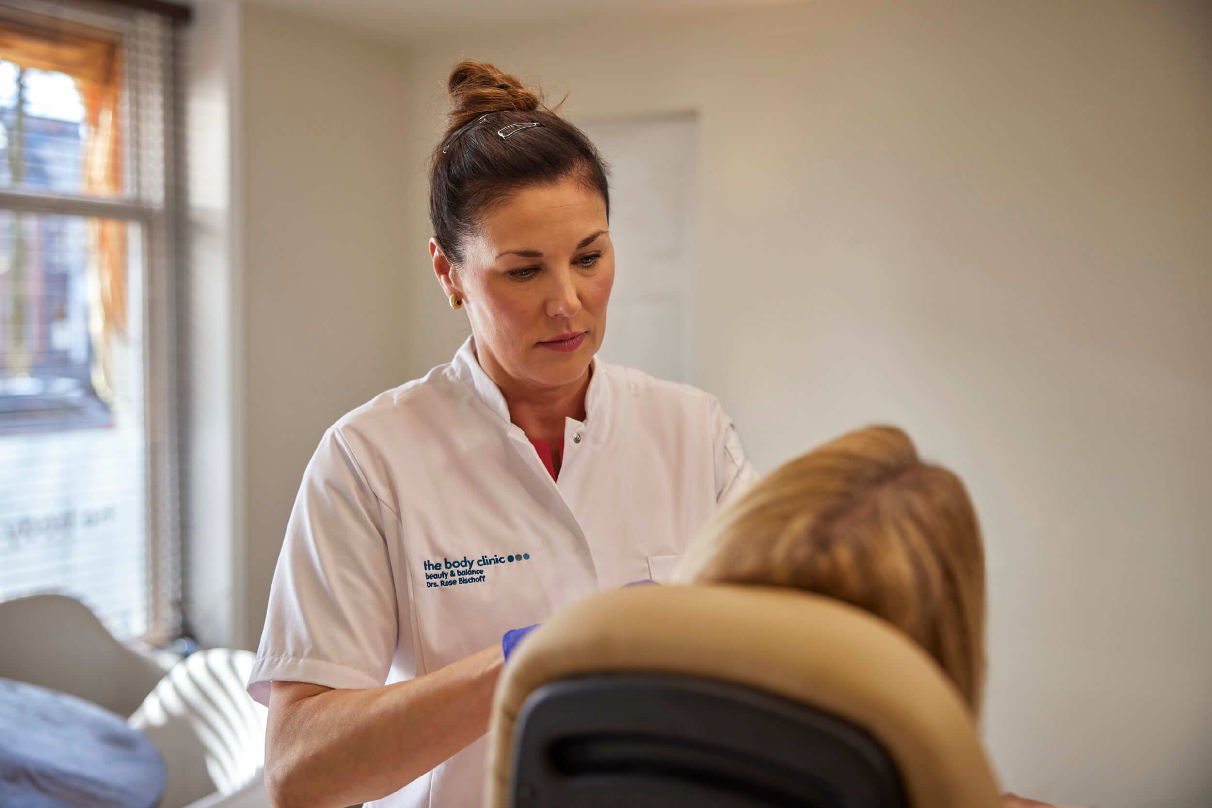 Cosmetisch arts Rose verwelkomt cliënt voor vrijblijvend consult bij The Body Clinic